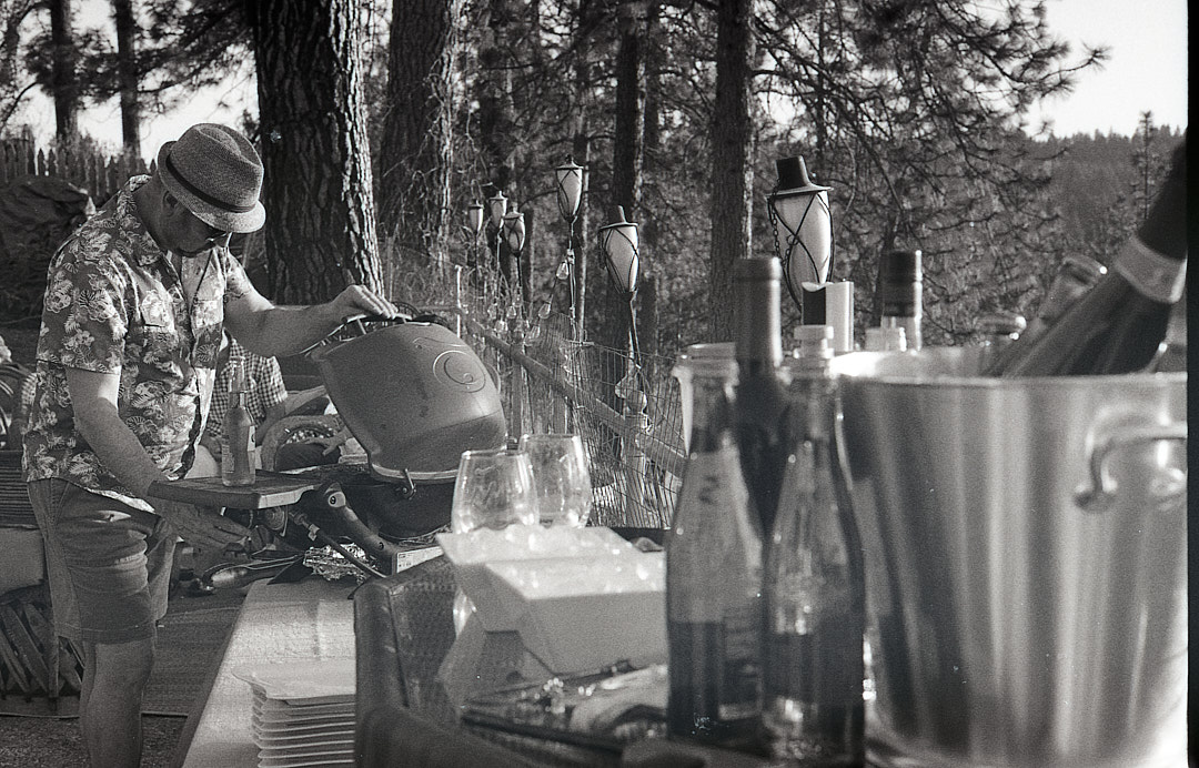 A man cooking outdoors during a gathering