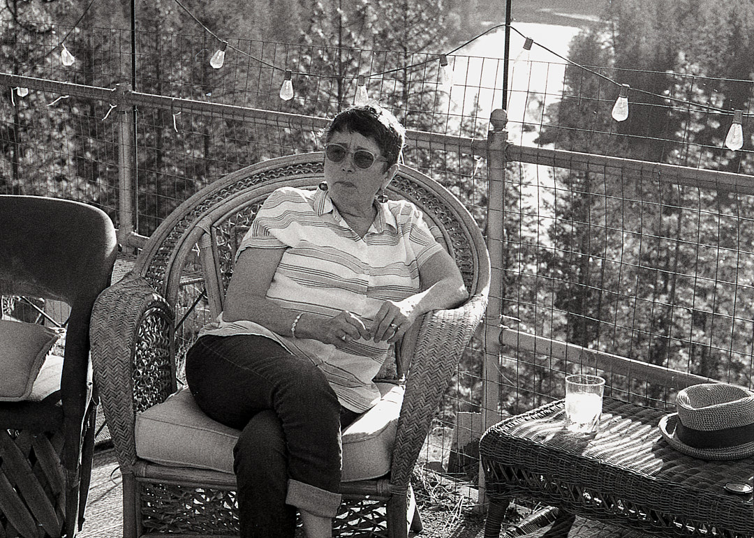 A person seated beneath string lights