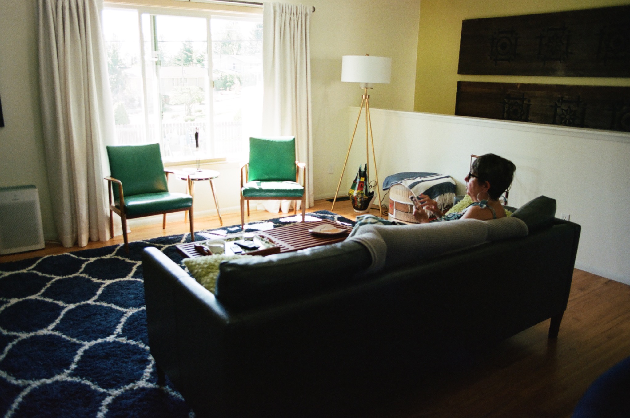 A woman sitting on a sofa in a bright living room