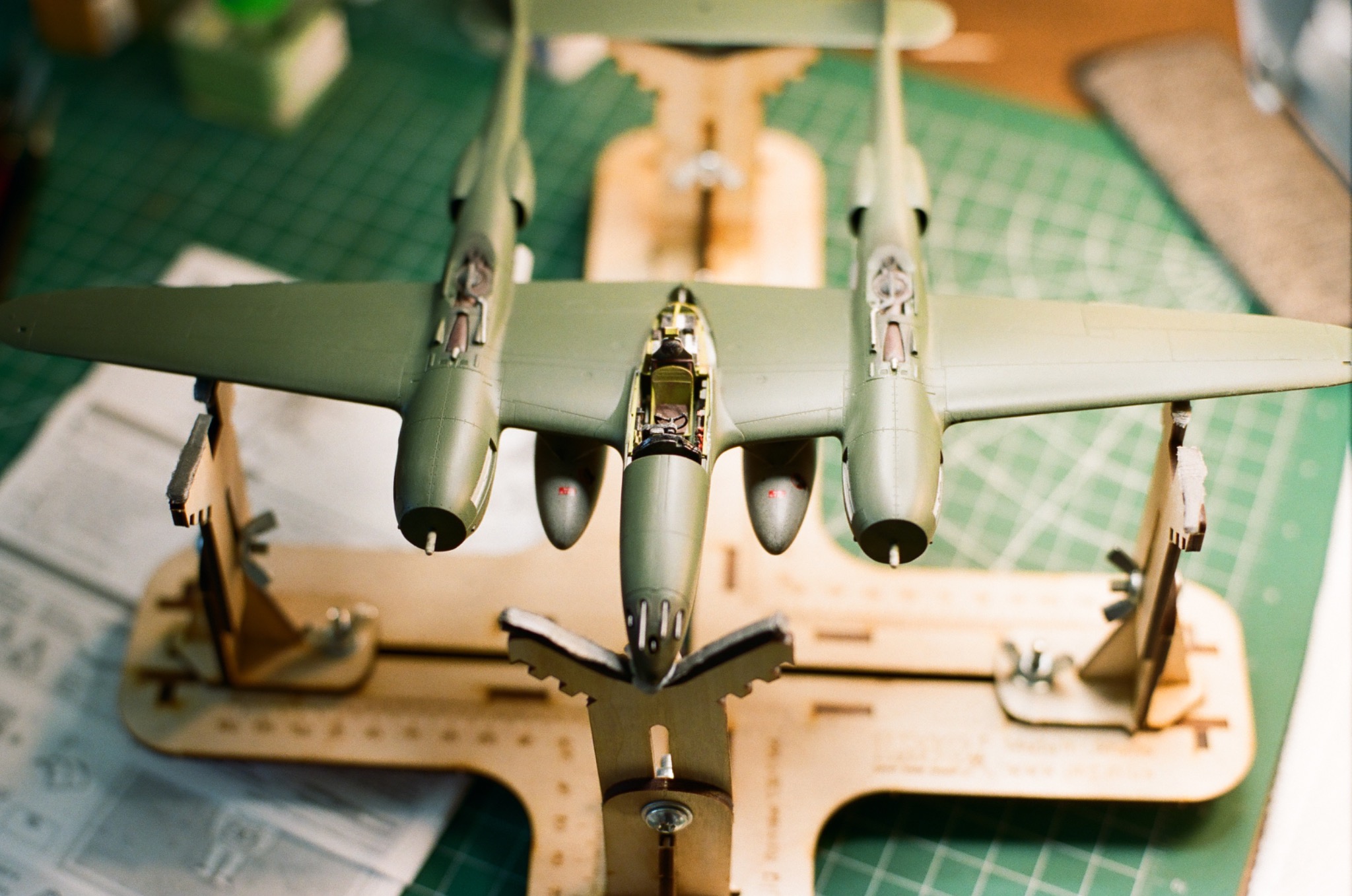 A model airplane held in a wooden work stand